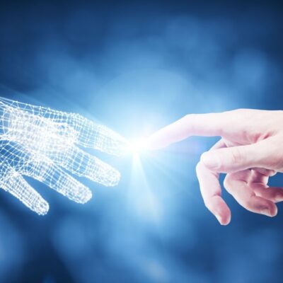 Tecnologias do futuro: mão humana e mão de ia se tocando.